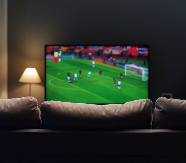 Football match on widescreen flat TV at home, sport and entertainment concept